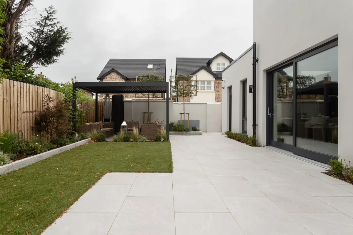 Pale paved patio beside a lawn and modern house